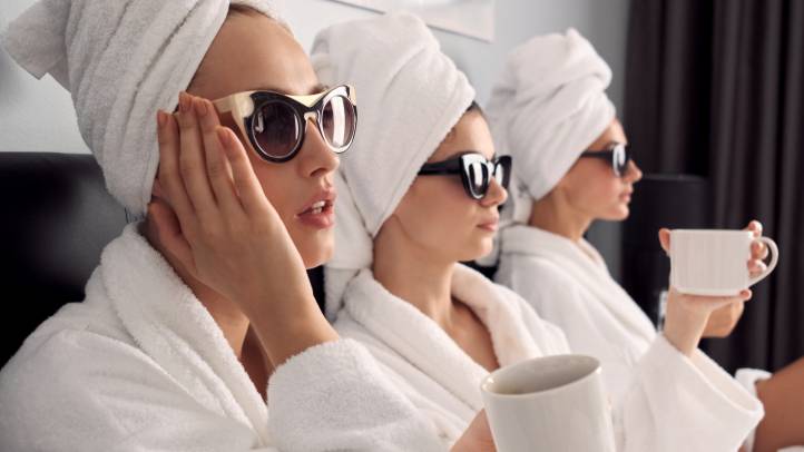 Frauen in Bademantel mit  Sonnenbrille und Kaffee