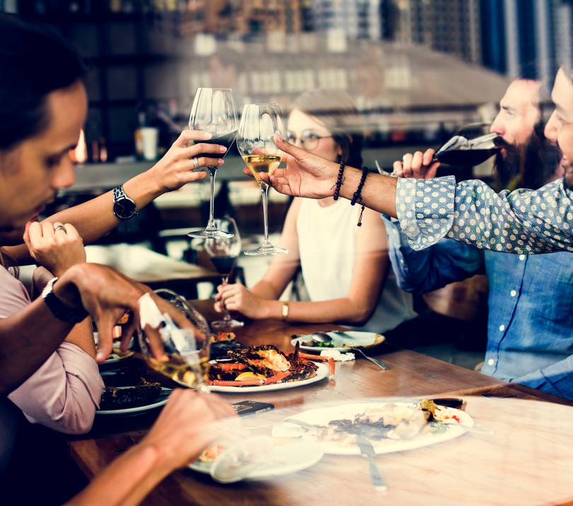 Freunde beim gemeinsamen Essen mit Wein